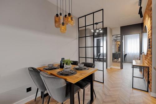 a dining room with a wooden table and chairs at Nr 9 EUROPA22 Apartament bądź Hostel in Tomaszów Mazowiecki