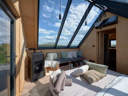 a living room with a large window and a couch at CAMPY ECO HOUSE • EGER in Egerszólát