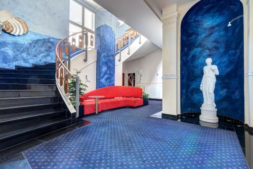 eine Treppe mit einem roten Sofa in einem Zimmer mit blauen Wänden in der Unterkunft Villa Seeschloss in Heringsdorf