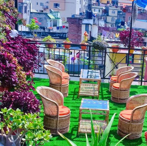 a group of chairs and tables on a balcony at Yog Hostel- Rooftop Yoga & Backpacker Social Stay in Thamel, Kathamndu in Kathmandu