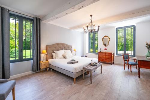 1 dormitorio con 1 cama, escritorio y ventanas en Le Bon Ami, en Fronsac
