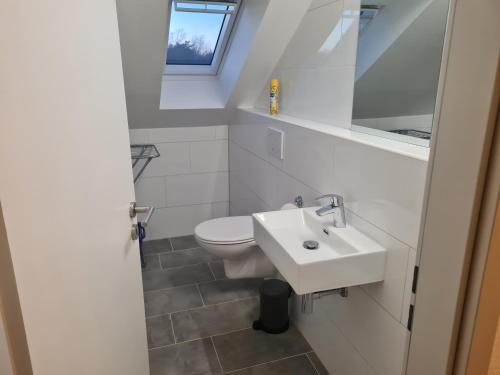 een witte badkamer met een toilet en een wastafel bij Oli-DGR, Monteurwohnung in Geeste