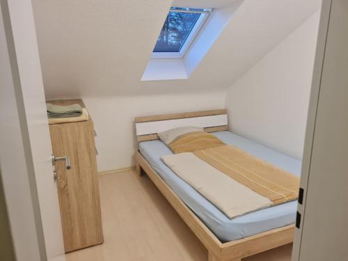 een kleine slaapkamer met een bed en een raam bij Oli-DGR, Monteurwohnung in Geeste