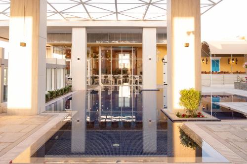 ドーハにあるMillennium Place Dohaのプールとロビーのある建物の景色を望めます。