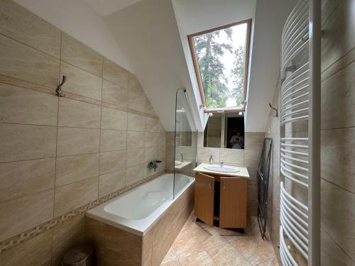 a bathroom with a bath tub and a sink at Családi Villa in Balatonszemes