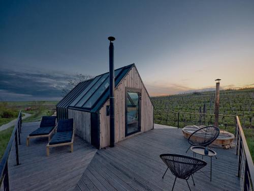 a small wooden house with chairs on a deck at CAMPY ECO HOUSE • EGER in Egerszólát