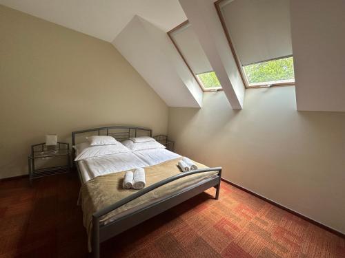 1 dormitorio con 1 cama con 2 zapatillas en Családi Villa, en Balatonszemes