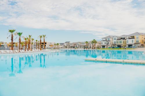 a large swimming pool with palm trees and condos at Paddle and Play townhouse in St. George