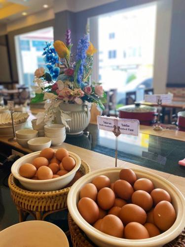 a table topped with bowls of eggs in baskets at Mayflower Grande Suite Hotel in Phitsanulok
