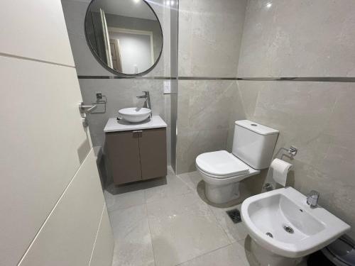 Luxury in San Telmo - Paseo de la Cisterna num6187 في بوينس آيرس: حمام مع مرحاض ومغسلة ومرآة