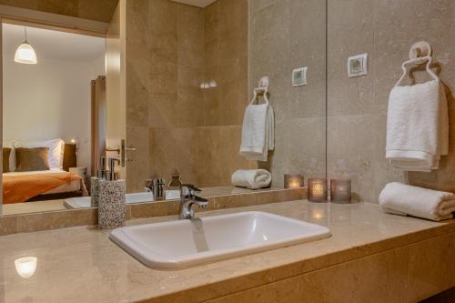La salle de bains est pourvue d'un lavabo et d'un miroir. dans l'établissement Kaizen Home & Pool, à Funchal