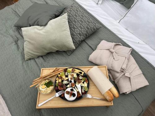 a plate of food on a tray on a bed at CAMPY ECO HOUSE • EGER in Egerszólát
