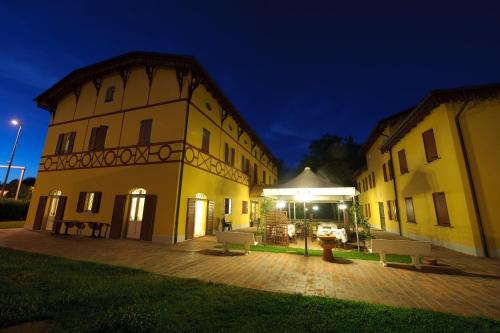 a couple of buildings with a courtyard at night at Corte Degli Estensi in Formigine