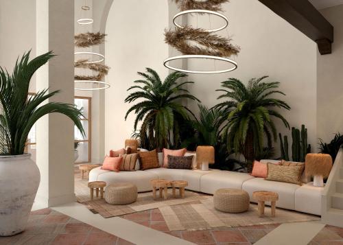 a living room with a couch and some plants at DAIA Slow Beach Hotel Conil - Adults Only Recommended in Conil de la Frontera