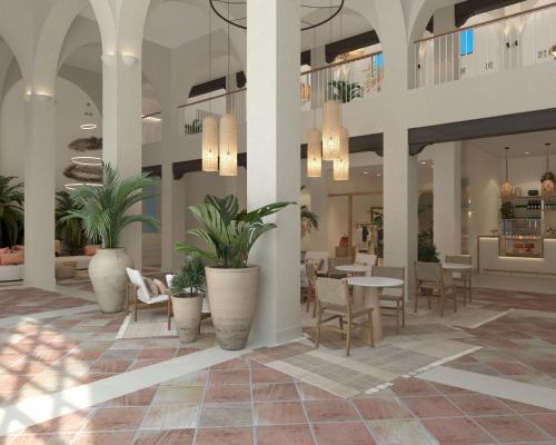 una hall con tavoli, sedie e piante in vaso di DAIA Slow Beach Hotel Conil - Adults Only Recommended a Conil de la Frontera