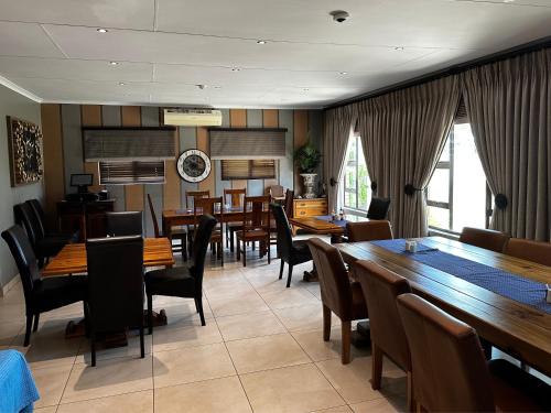 Jwaneng的住宿－Meyers Guesthouse，用餐室配有木桌和椅子