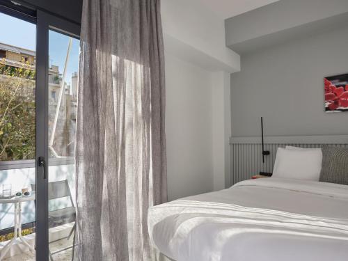 a bedroom with a bed and a large window at Athens Project Luxury Apartments in Athens