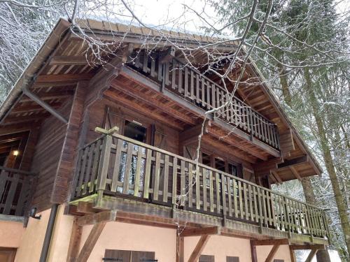 une cabane dans les arbres avec un balcon dans les bois dans l'établissement LE MONTAGNARD Chalet en bois, à La Bresse