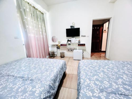 台東市的住宿－正一民宿，一间卧室配有两张床和电视