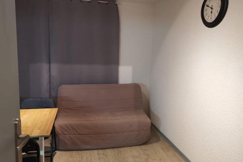 a room with a couch and a clock on a wall at Au cœur des Cîmes en Chartreuse in Saint-Pierre-de-Chartreuse
