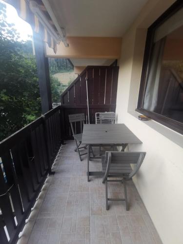 a patio with a table and chairs on a balcony at Au cœur des Cîmes en Chartreuse in Saint-Pierre-de-Chartreuse