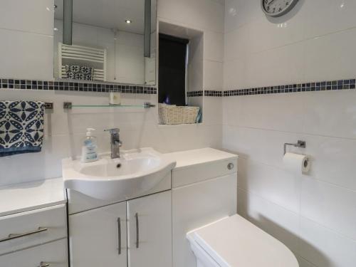 a white bathroom with a sink and a toilet at 19 Slinger Road in Cleveleys