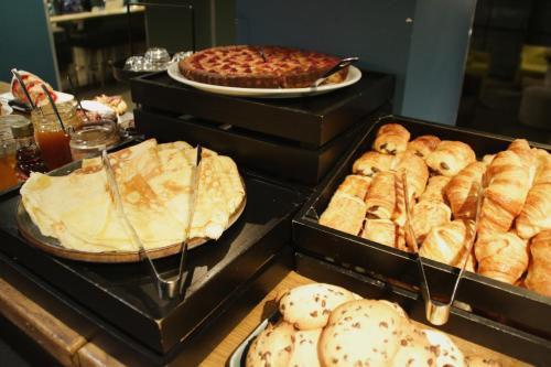 a buffet with different types of bread and pies at Hotel De France in Valence