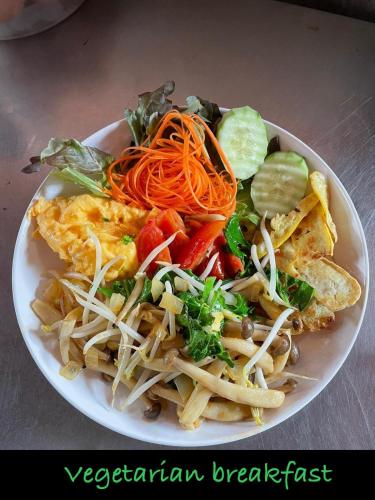 un plato de comida con fideos y verduras en una mesa en Jing Jo Boutique Bungalow, en Sam Roi Yot