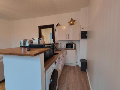 une cuisine avec des armoires blanches et un comptoir dans l'établissement Appart'HomeCity - Rouen Marne Impressionniste, à Rouen