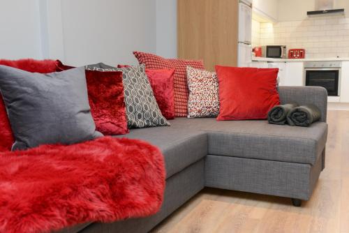 a couch with colorful pillows on it in a living room at The RED KEEP Fab Location - Two Bed - Two Bathrooms -Townhouse in Galway