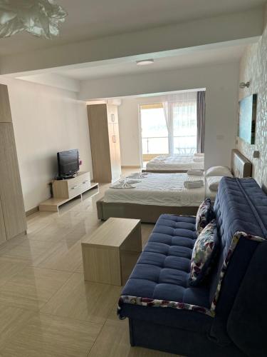 1 dormitorio con 2 camas, sofá y TV en AURA Apartments, en Budva