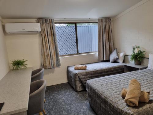 um quarto de hotel com duas camas e uma janela em Y Motels Yarraman em Yarraman
