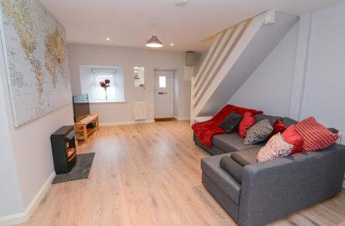 a living room with a couch and a staircase at The RED KEEP Fab Location - Two Bed - Two Bathrooms -Townhouse in Galway