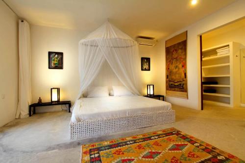 a bedroom with a white bed with a canopy at Villa Mutiara Putih by Optimum Bali Villas in Seminyak