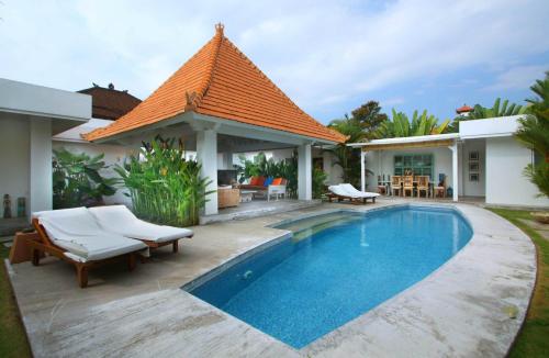 a villa with a swimming pool and a house at Villa Mutiara Putih by Optimum Bali Villas in Seminyak