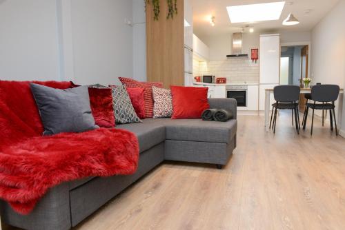 a living room with a gray couch with red pillows at The RED KEEP Fab Location - Two Bed - Two Bathrooms -Townhouse in Galway