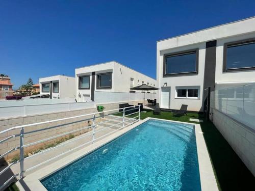 a house with a swimming pool in front of a house at Nueva Casa with Private POOL in Puerto Marino
