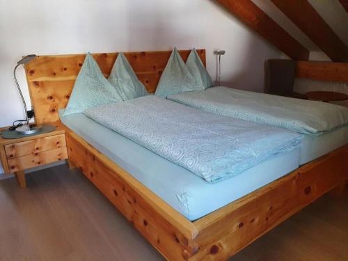 um quarto com uma cama de madeira com lençóis azuis em Chesa Foppas App Nr 7 em Sils Maria