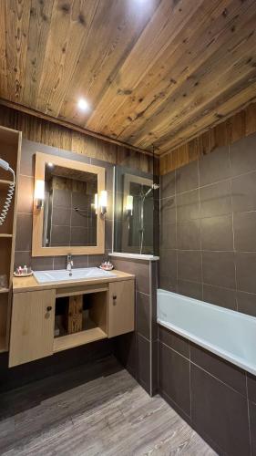 une salle de bain avec un lavabo et une baignoire dans l'établissement Résidence CHALET DE SOLAISE - Studio 30 m2 - by MONTBLANC LODGE, à Val dʼIsère