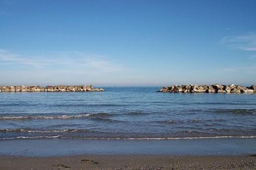 a group of rocks in the water next to a beach at Casa del Fiordaliso in San Benedetto del Tronto