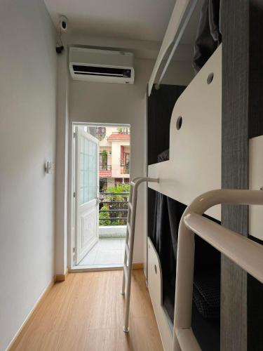 a room with a staircase leading to a room with a door at Alphabet Home Capsule in Ho Chi Minh City