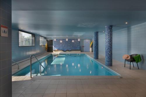 a large swimming pool in a building at DOMITYS LE PARC DES AUBIERS in Poissy