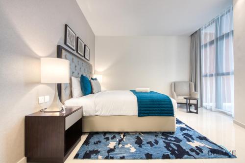 a bedroom with a bed and a blue rug at Cordial 1BR at Celestia B Dubai South by Deluxe Holiday Homes in Dubai