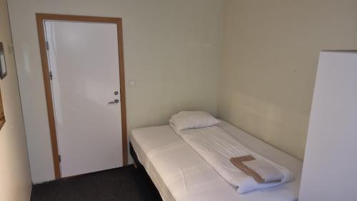 a small room with a bed and a door at Igdlo Guesthouse in Reykjavík