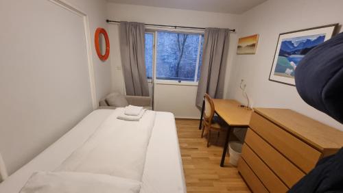 a small room with a white bed and a table at Igdlo Guesthouse in Reykjavík