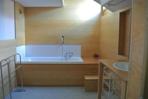 baño grande con bañera y lavamanos en Chesa Perini-Albertini en La Punt-Chamues-ch
