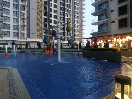 a pool in the middle of a city with tall buildings at K AVENUE B17 house room near airport by Gc in Kota Kinabalu