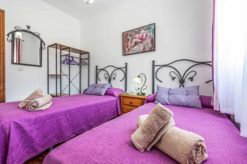 - 2 lits dans une chambre avec des draps violets dans l'établissement Villa Dos Hermanas, à Frigiliana
