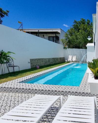 a swimming pool in a backyard with a white fence at Batavia Boutique Hotel in Stellenbosch
