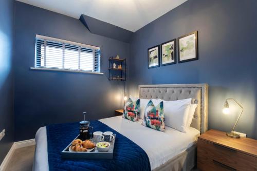 a bedroom with a bed with a tray of food on it at Elliot Oliver - Loft Style 2 Bedroom Apartment With Parking In The Docks in Gloucester